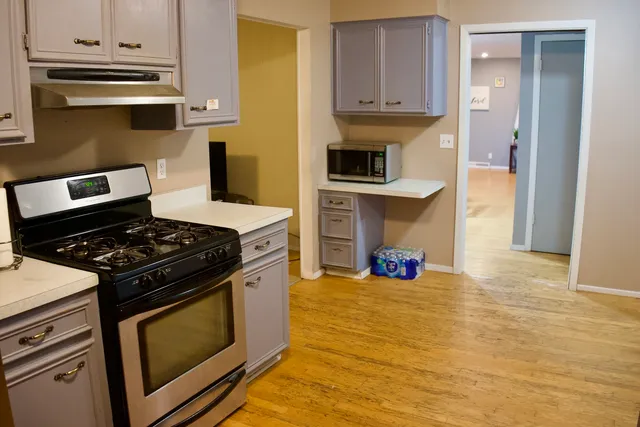 a kitchen with stainless steel appliances a stove a microwave and cabinets