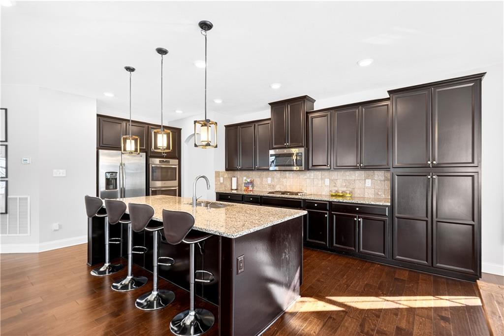 1444 Main Street Pittsburgh, PA 15241 - Photo 13 of 50 a kitchen with stainless steel appliances granite countertop a stove top oven a kitchen island a table and chairs