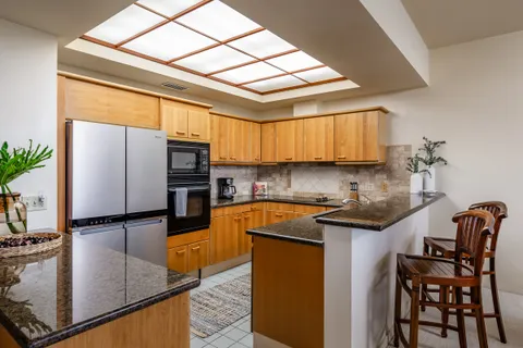 a kitchen with stainless steel appliances granite countertop a stove a sink and a refrigerator