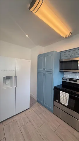 a kitchen with a refrigerator and a stove