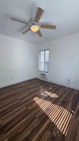 a view of a room with wooden floor and window