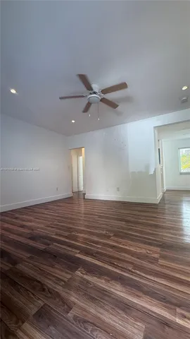 a view of a room with wooden floor and white walls