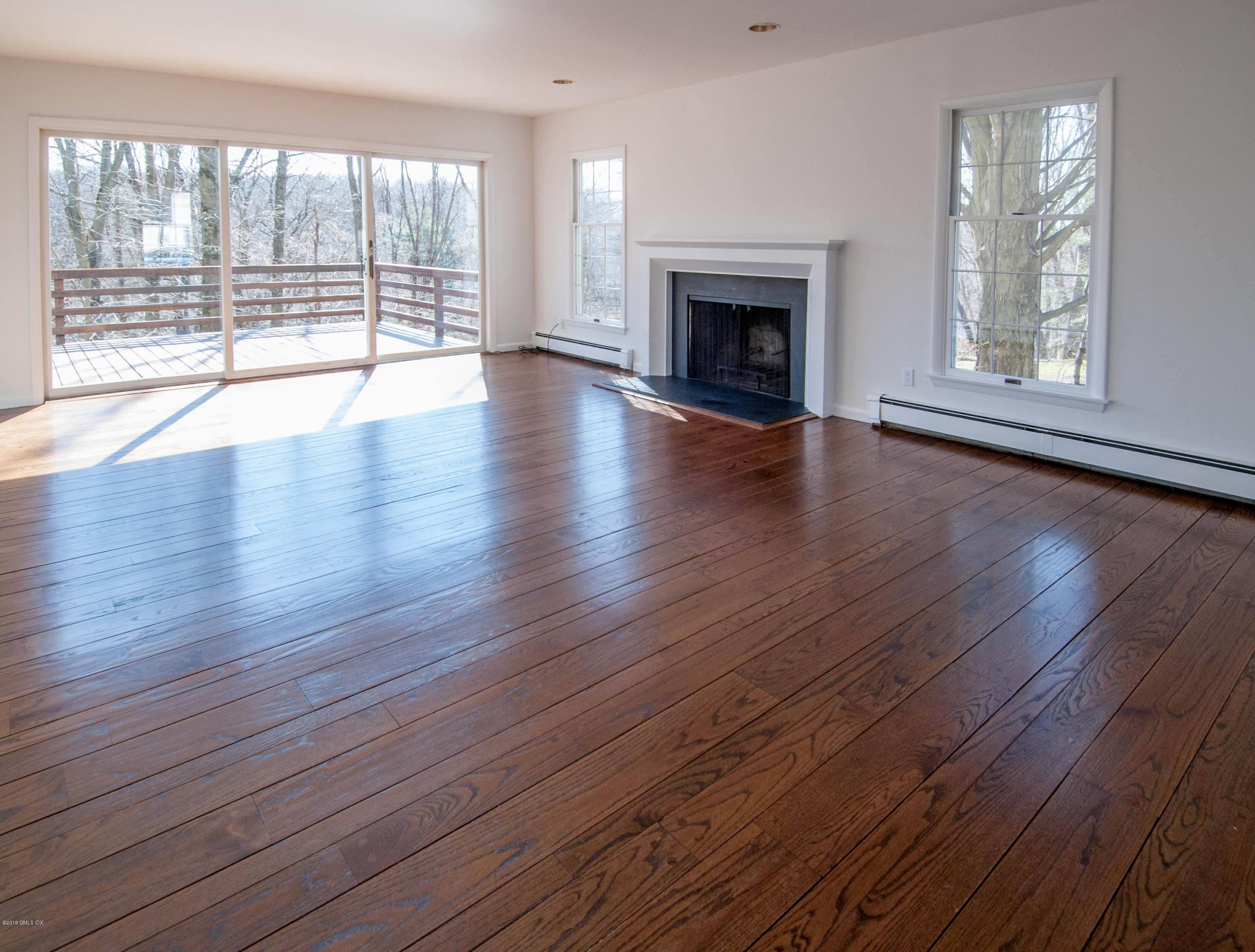 25 Harkim Road Greenwich, CT 06831 - Photo 6 of 14 an empty room with wooden floor and fireplace