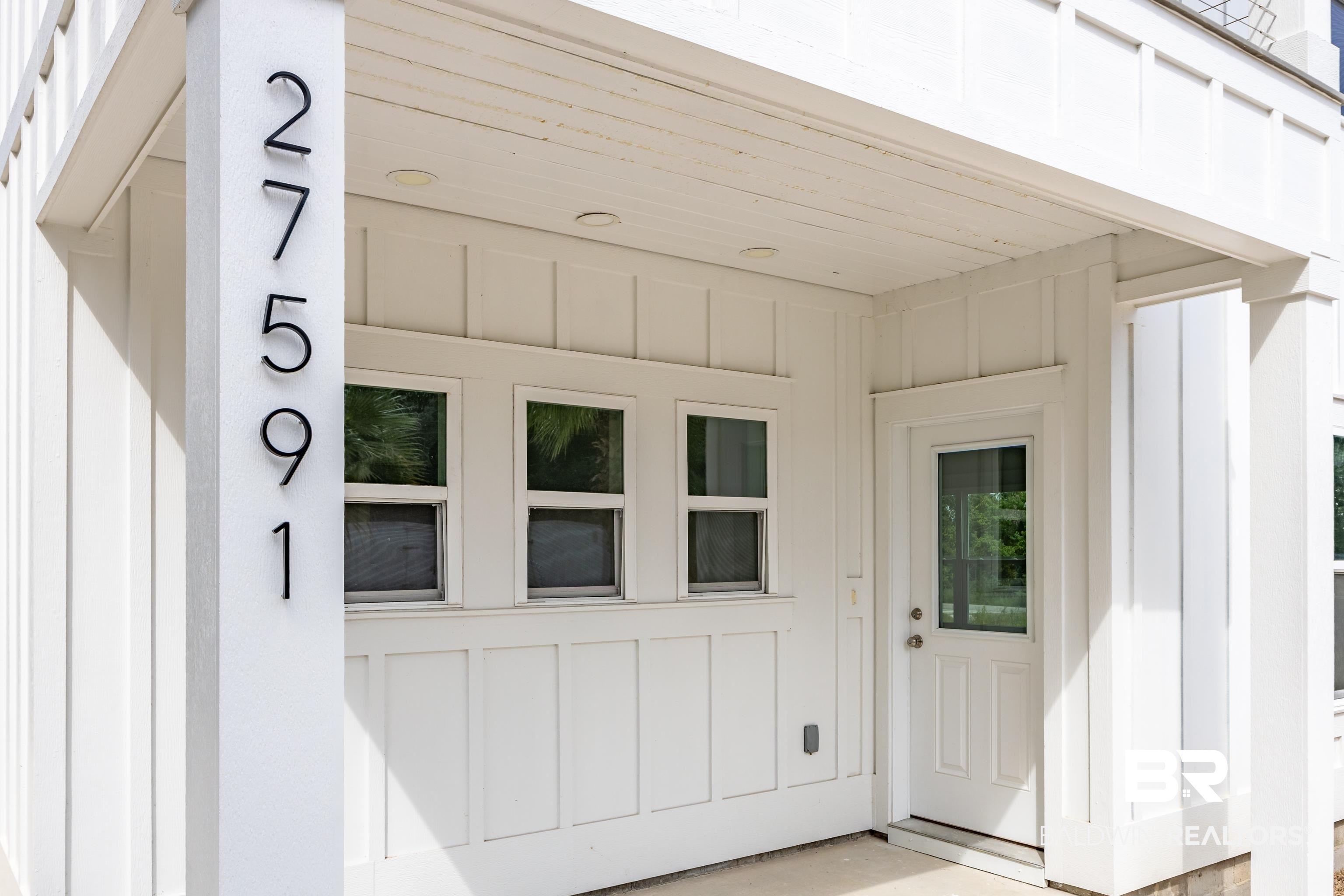 27591 Canal Road Orange Beach, AL 36561 - Photo 4 of 51 View of exterior entry with board and batten siding and a patio