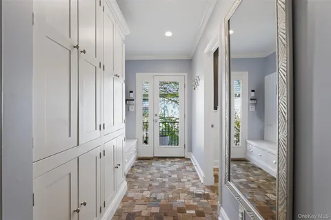 a view of a hallway to a livingroom with wooden floor and windows