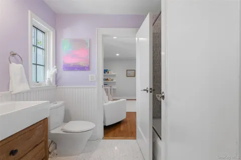 a bathroom with a sink a toilet a tub and a mirror