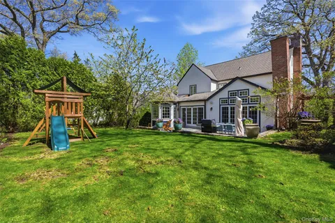 a view of a house with backyard and a tree