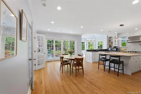 a kitchen with a table chairs and wooden floor