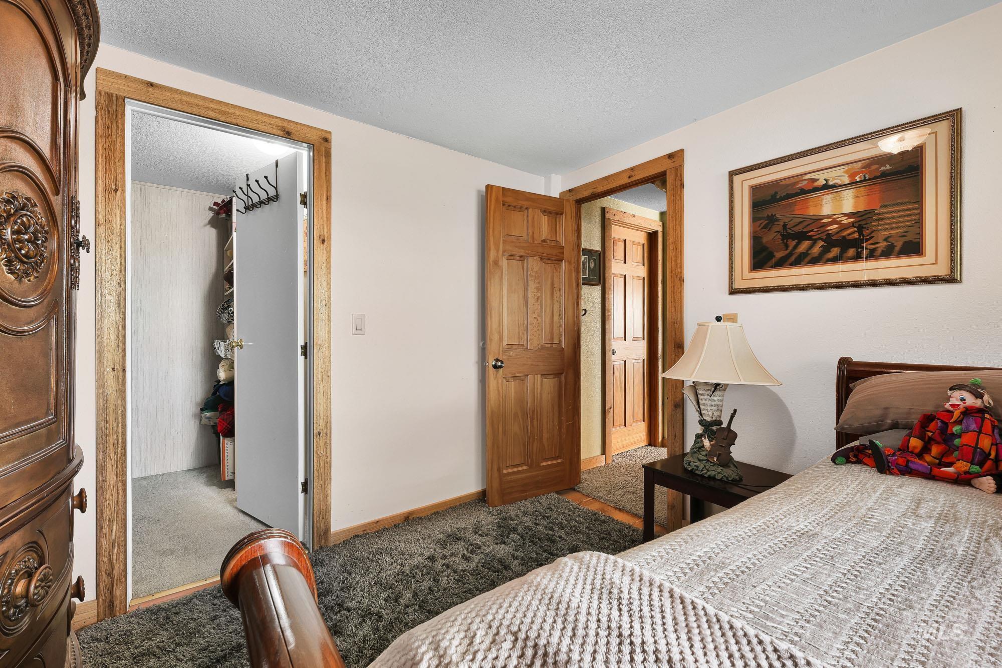24900 Market Road Parma, ID 83660 - Photo 15 of 50 Bedroom featuring light-colored walls, textured carpeting, and natural wood trim