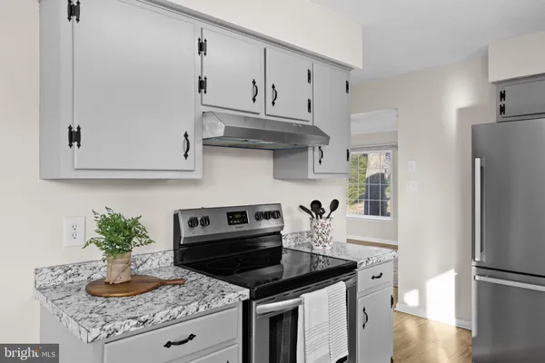 a kitchen with granite countertop a stove and a refrigerator