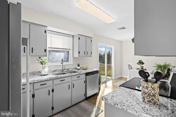 a kitchen with stainless steel appliances granite countertop a sink stove and cabinets