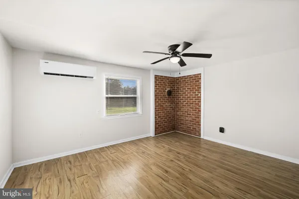 a view of room with hardwood floor and a ceiling fan