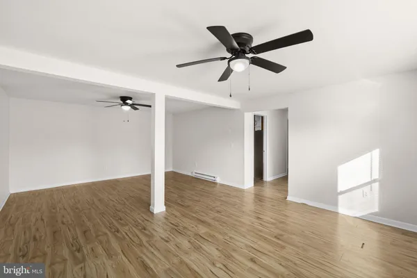 a view of a room with wooden floor and ceiling fan