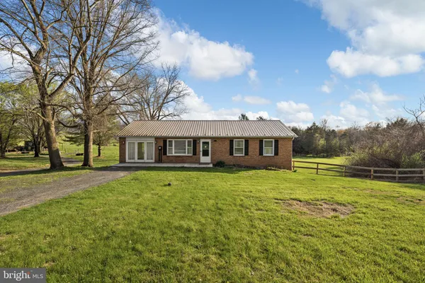 a view of a big house with a big yard and large trees