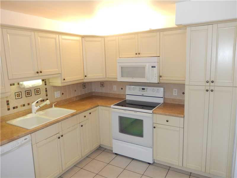 370 Racquet Club Road, Unit 203 Weston, FL 33326 - Photo 4 of 16 a kitchen with white cabinets and white appliances