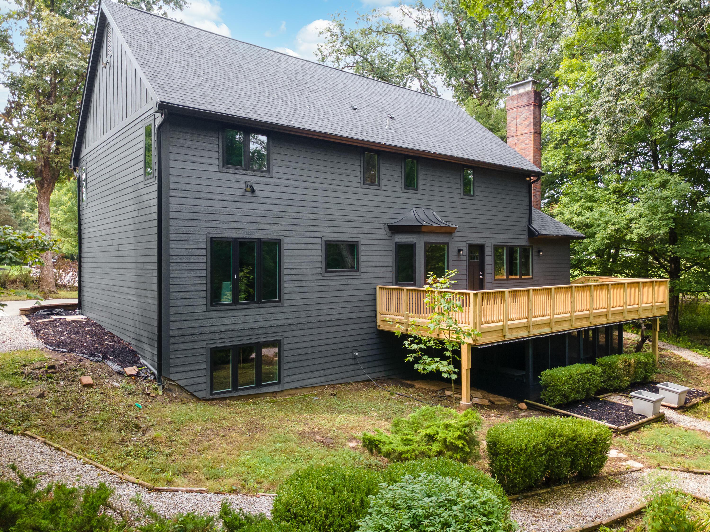 1560 Carriage Road Powell, OH 43065 - Photo 56 of 73 Dark gray horizontal siding, black trim windows, a newly constructed wood deck, and a brick chimney
