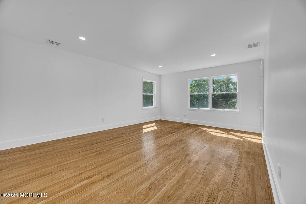 717 Holmdel Road Holmdel, NJ 07733 - Photo 23 of 39 an empty room with wooden floor and windows