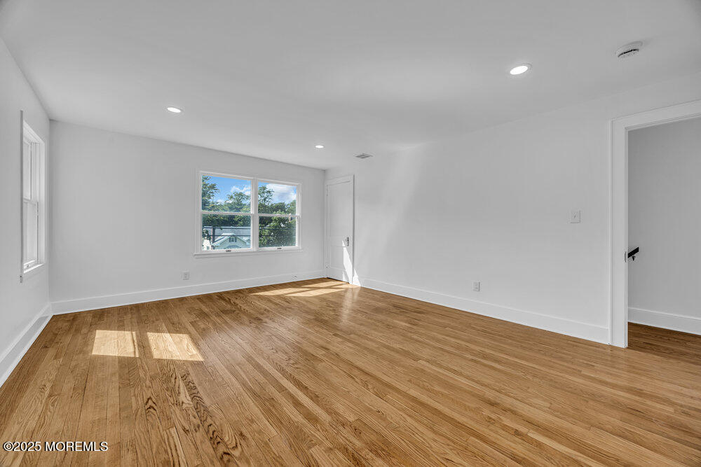 717 Holmdel Road Holmdel, NJ 07733 - Photo 25 of 39 an empty room with wooden floor and windows