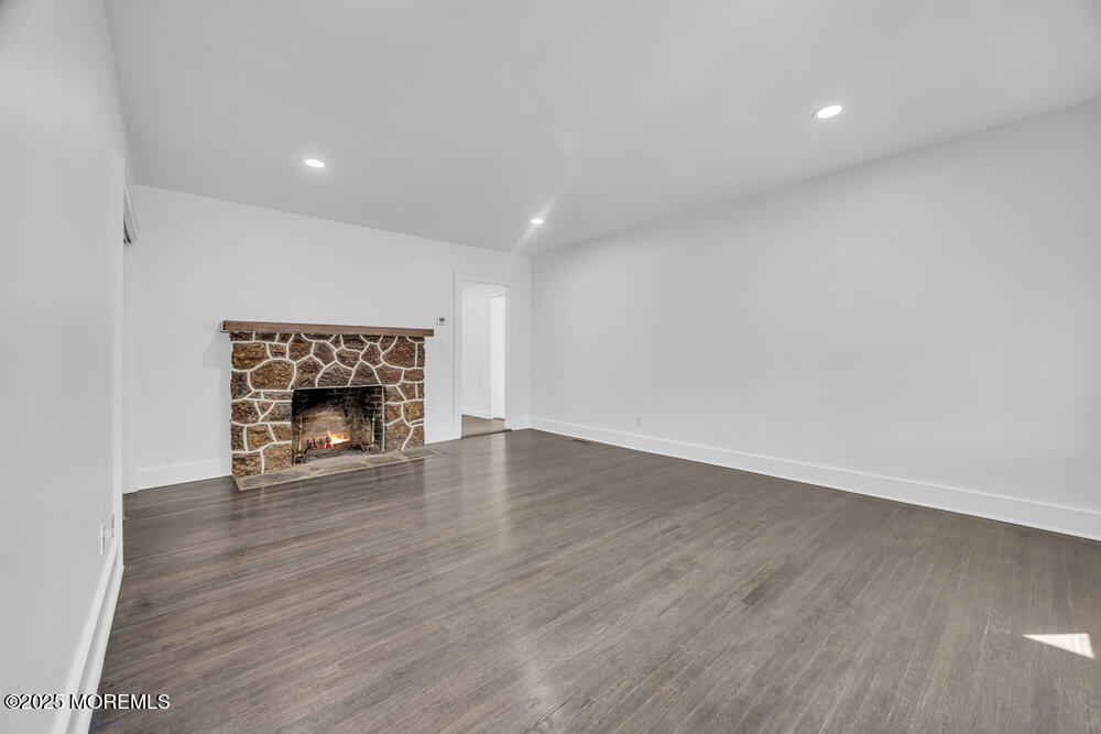717 Holmdel Road Holmdel, NJ 07733 - Photo 7 of 39 a view of an empty room with wooden floor and a fireplace