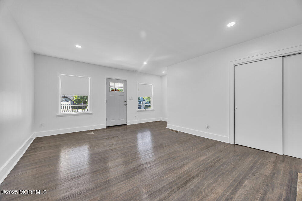 717 Holmdel Road Holmdel, NJ 07733 - Photo 10 of 39 an empty room with wooden floor and windows