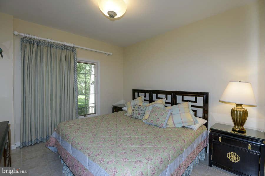 9017 Clewerwall Drive Bethesda, MD 20817 - Photo 22 of 27 a bedroom with a bed a lamp and a window