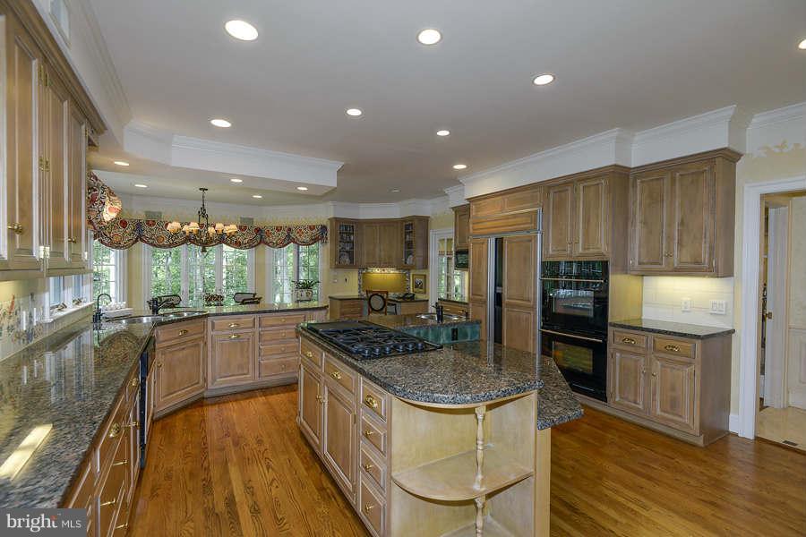 9017 Clewerwall Drive Bethesda, MD 20817 - Photo 8 of 27 a kitchen with stainless steel appliances granite countertop a stove top oven a refrigerator a sink and a counter space