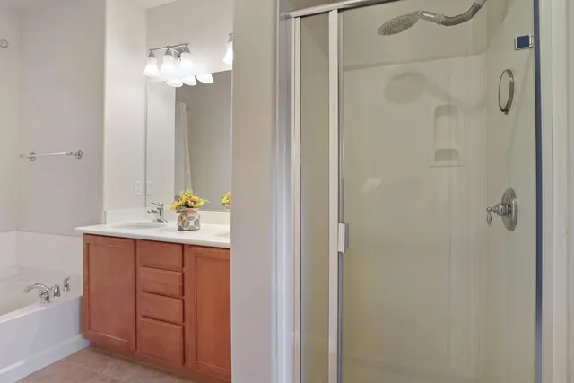 a bathroom with a tub a sink and mirror