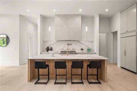 a kitchen with kitchen island stainless steel appliances a sink and a refrigerator