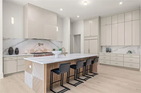 a kitchen with a table a sink cabinets and stainless steel appliances