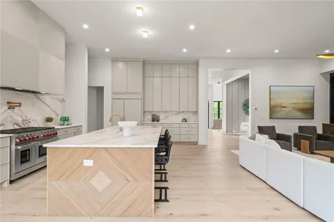 a large kitchen with stainless steel appliances kitchen island granite countertop a sink and cabinets