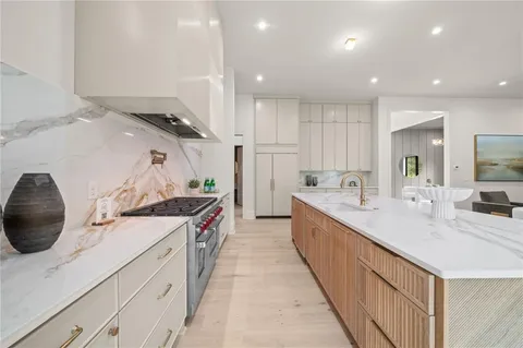 a large kitchen with stainless steel appliances lots of counter space and wooden floor