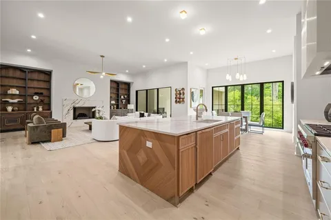 a large kitchen with stainless steel appliances a large counter top a stove and a refrigerator