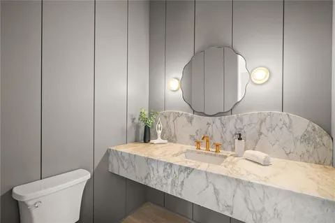 a bathroom with a granite countertop sink a mirror and toilet