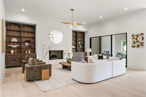 a living room with furniture a fireplace and a chandelier