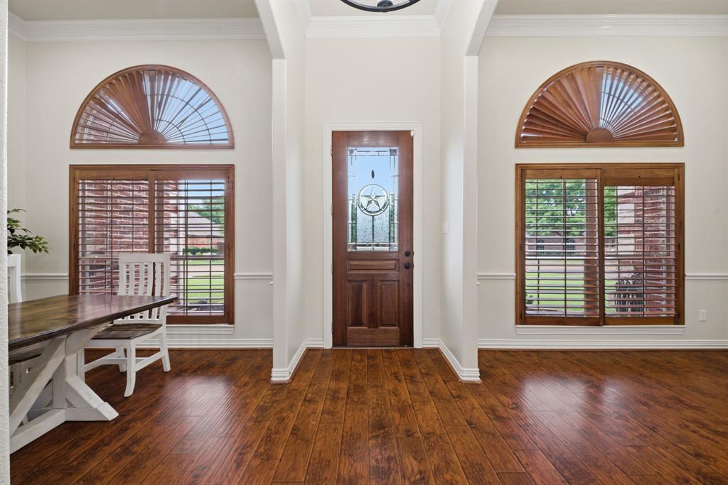 603 Cedar Drive Pilot Point, TX 76258 - Photo 3 of 39 Entryway featuring rich wood-finish flooring, a solid wood front door with decorative glass, and two sets of large windows with custom wood shutters