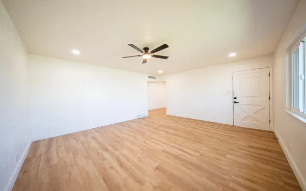 a view of a big room with wooden floor and a ceiling fan