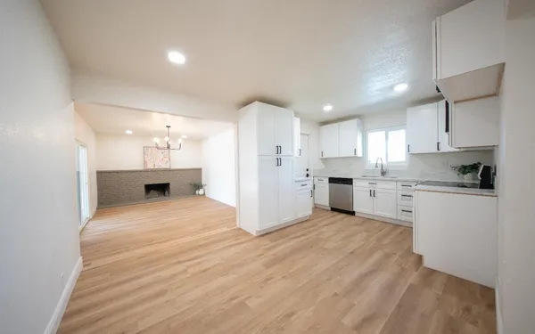 a large white kitchen with white cabinets and stainless steel appliances