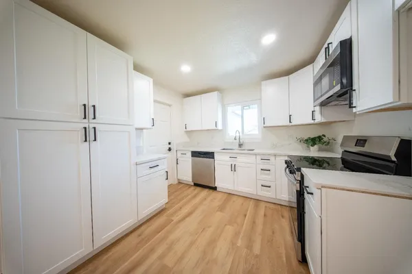 a kitchen with white cabinets and white appliances