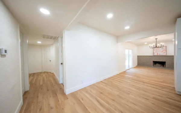 a view of a room & wooden floor and a kitchen