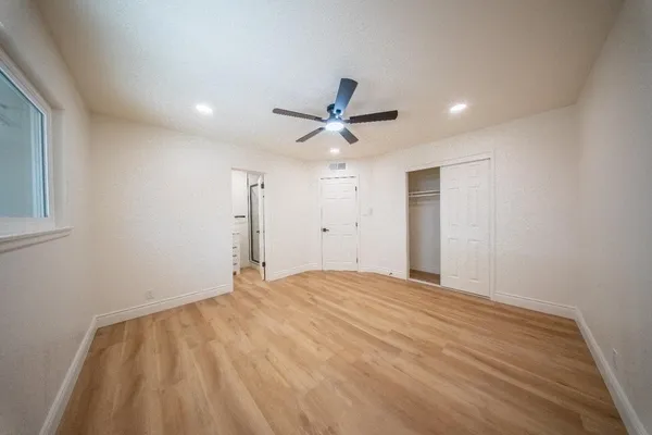 a view of an empty room with a ceiling fan