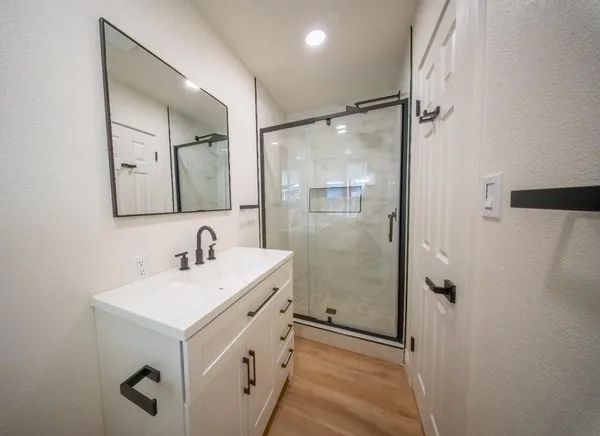 a bathroom with a sink mirror and shower