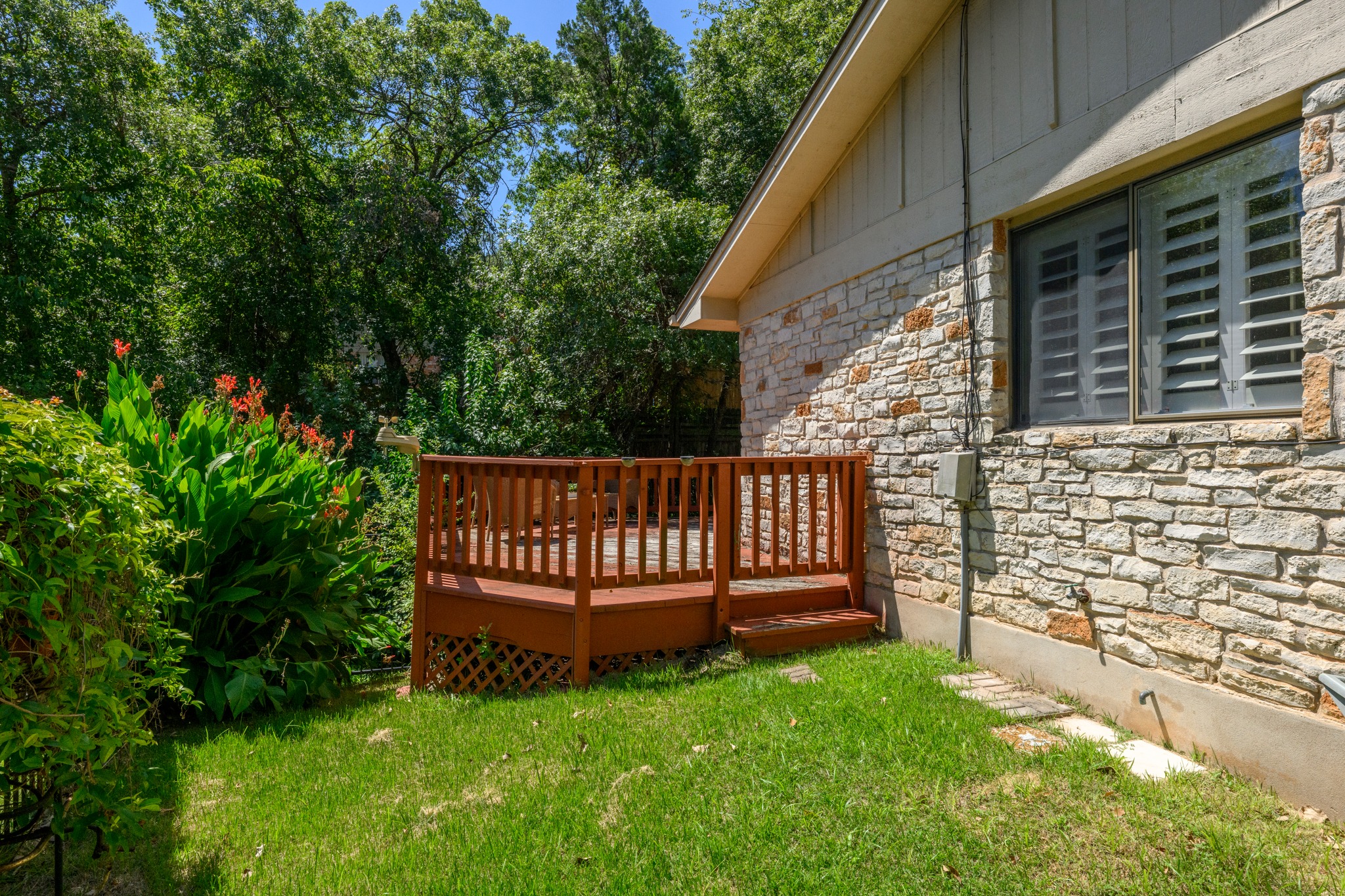 1907 Stoneridge Road Austin, TX 78746 - Photo 35 of 36 Stone exterior, grassy side yard, and easy access to the spacious deck.