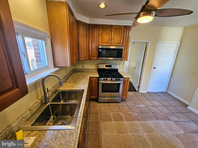 a kitchen with stainless steel appliances a stove a sink and a microwave
