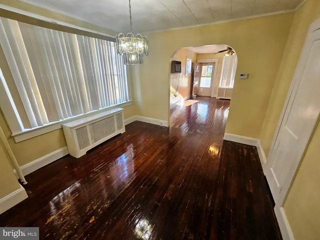 a view of a hallway with wooden floor and stairs