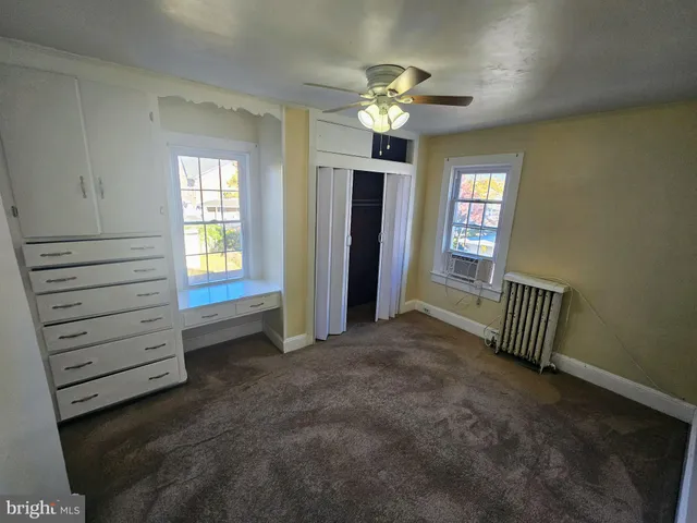 en empty room with windows and chandelier