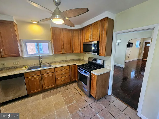 a kitchen with stainless steel appliances granite countertop a stove a sink and a refrigerator