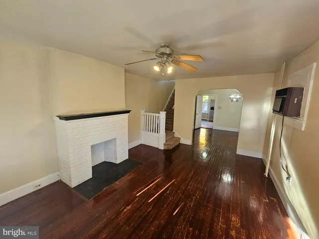 a view of a hallway with wooden floor and a fireplace