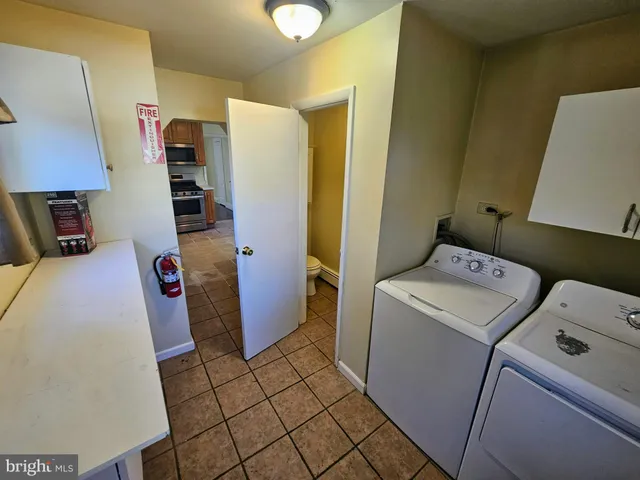 a view of storage and utility room with fridge and wooden floor