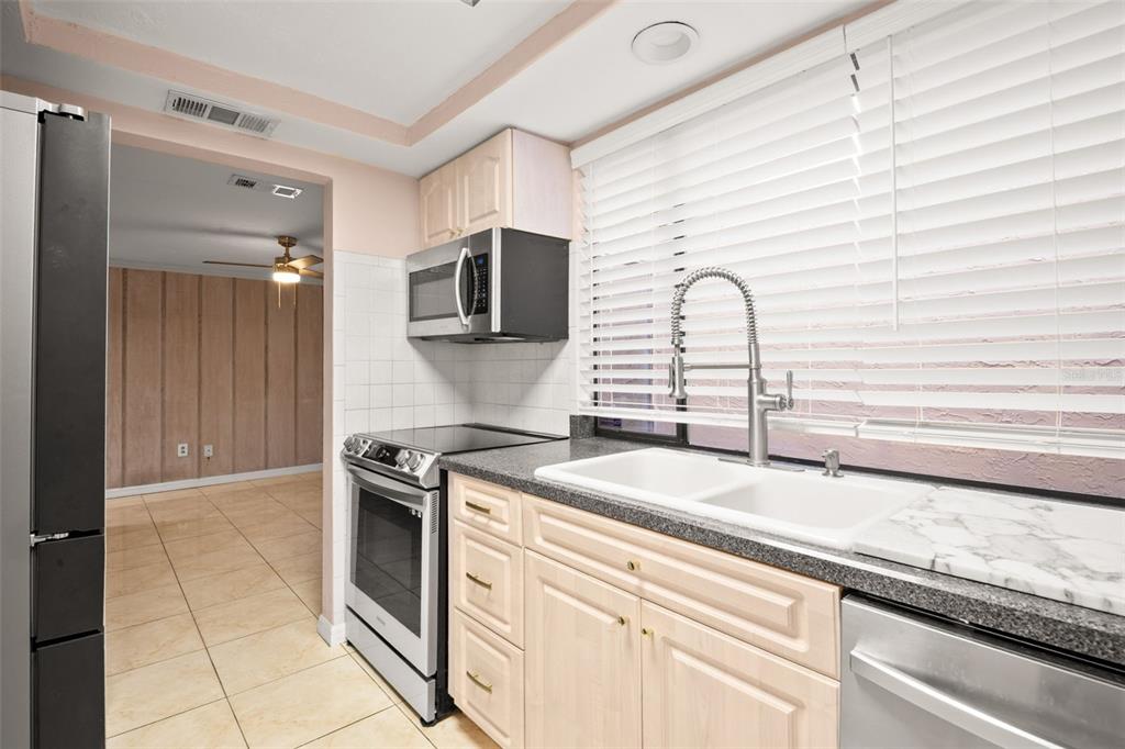 7500 Rocky Point Drive Hudson, FL 34667 - Photo 15 of 37 a kitchen with granite countertop a sink stainless steel appliances and cabinets