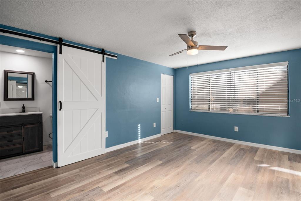 7500 Rocky Point Drive Hudson, FL 34667 - Photo 21 of 37 a view of empty room with wooden floor and fan
